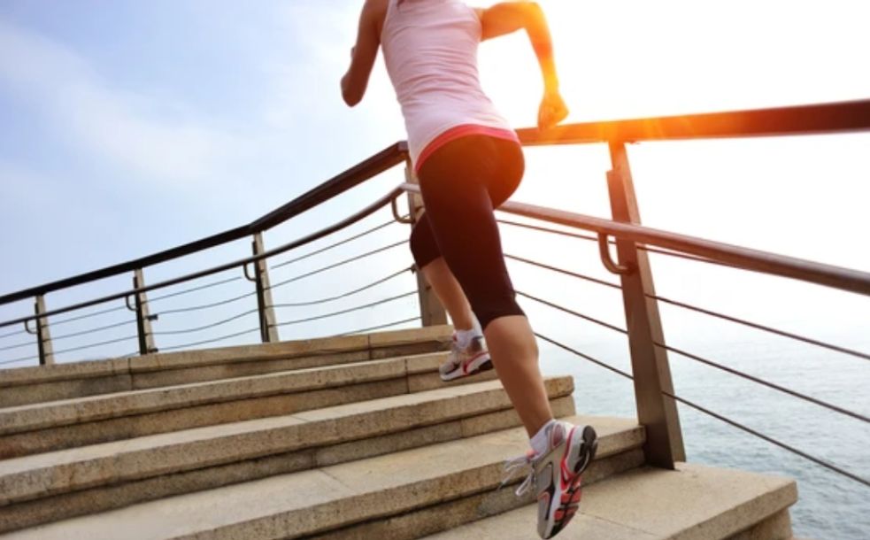 A woman running up some stairs in the sun
