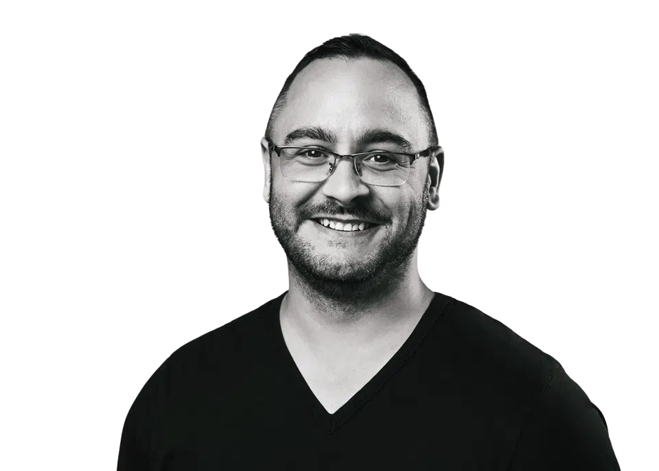 A man with glasses and beard smiling for the camera.