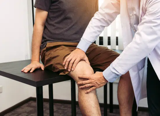 A man sitting down on the side of his leg