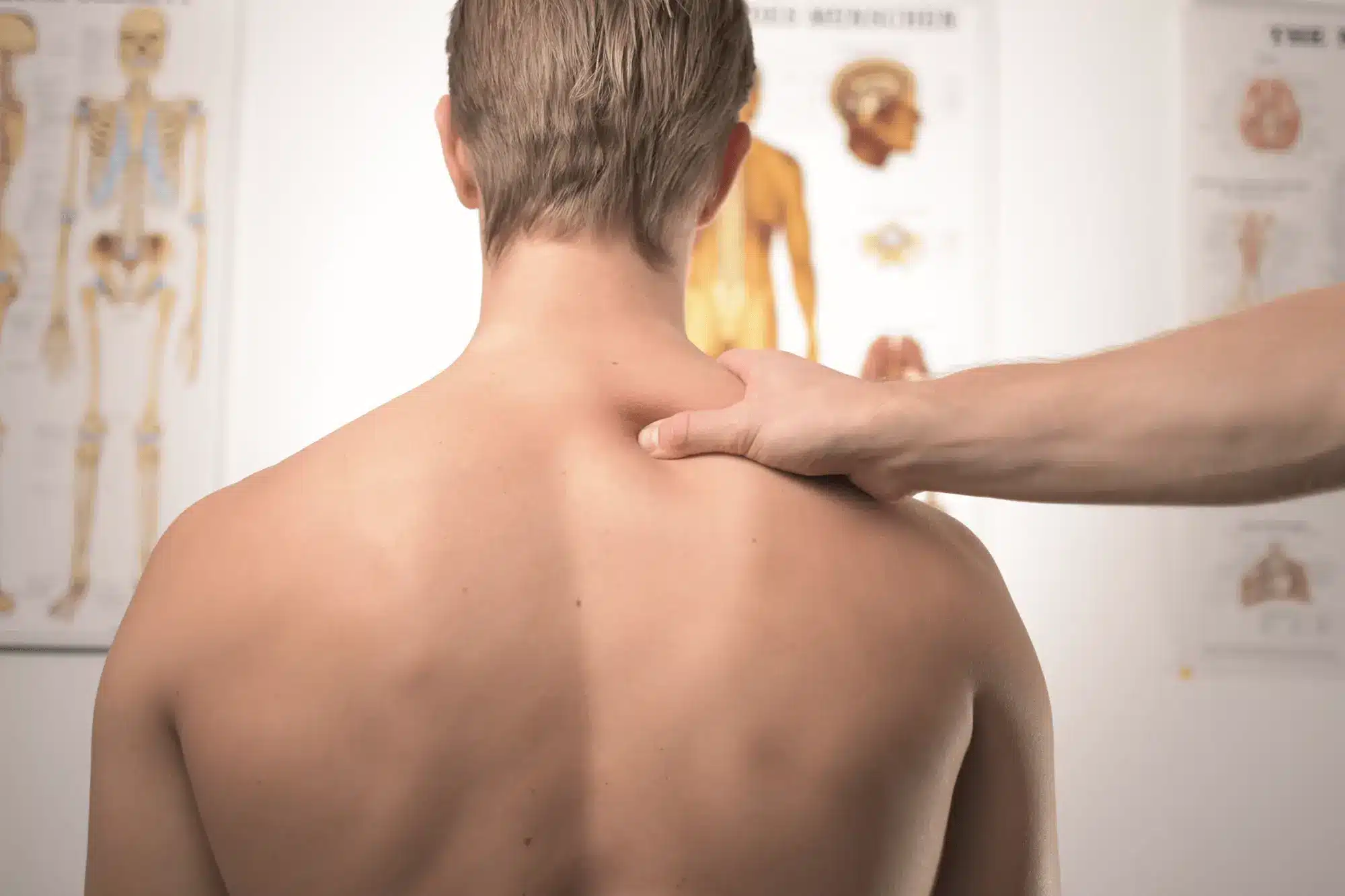 Person receiving shoulder massage in medical office.